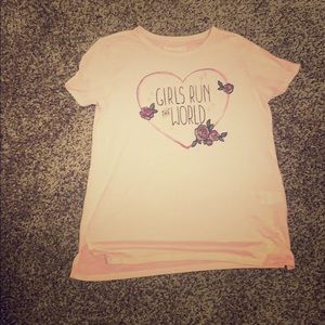 A pink shirt with the print,“Girls run the World”